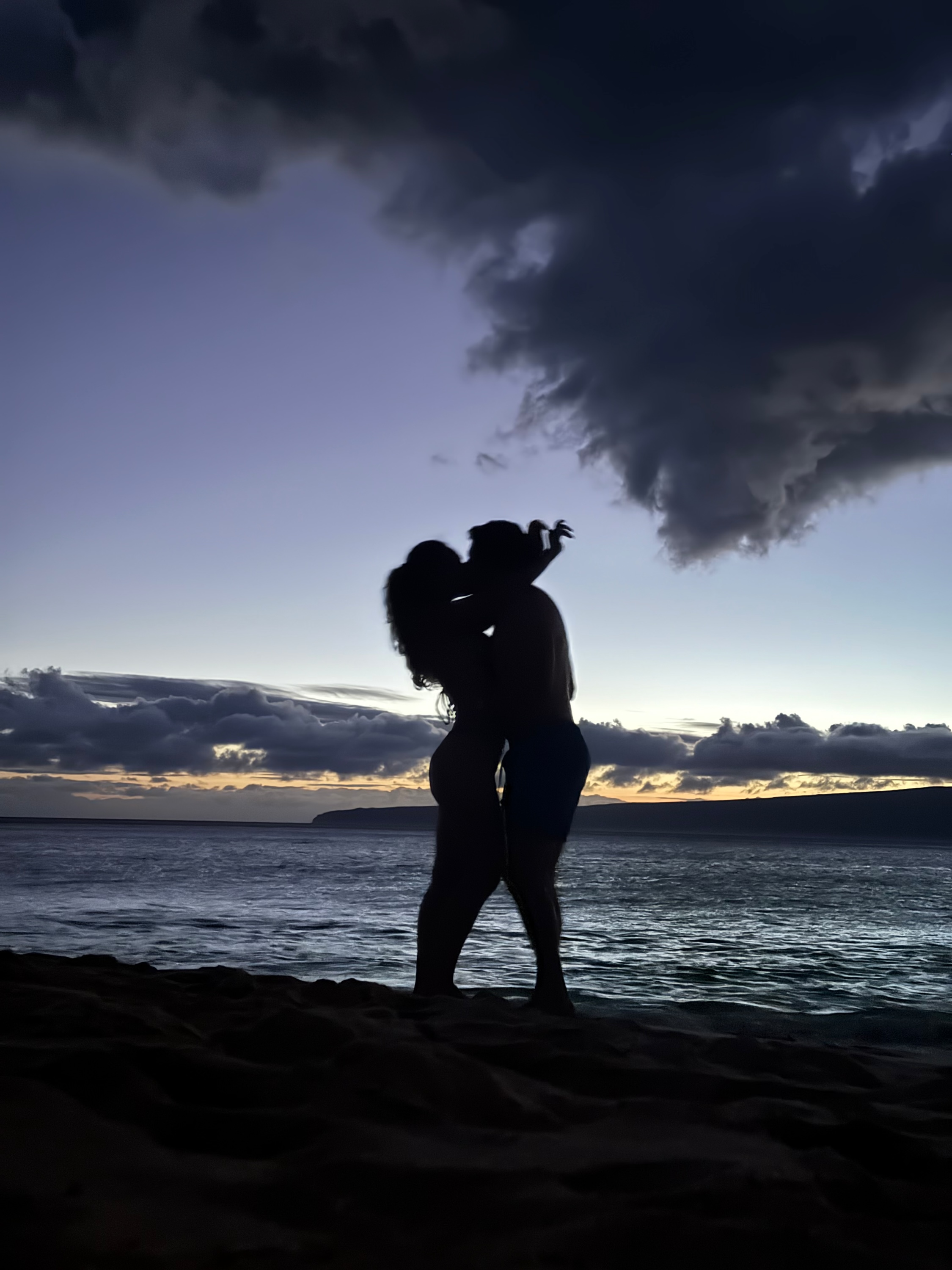 Foivos and Alexandra kissing on the beach at dusk