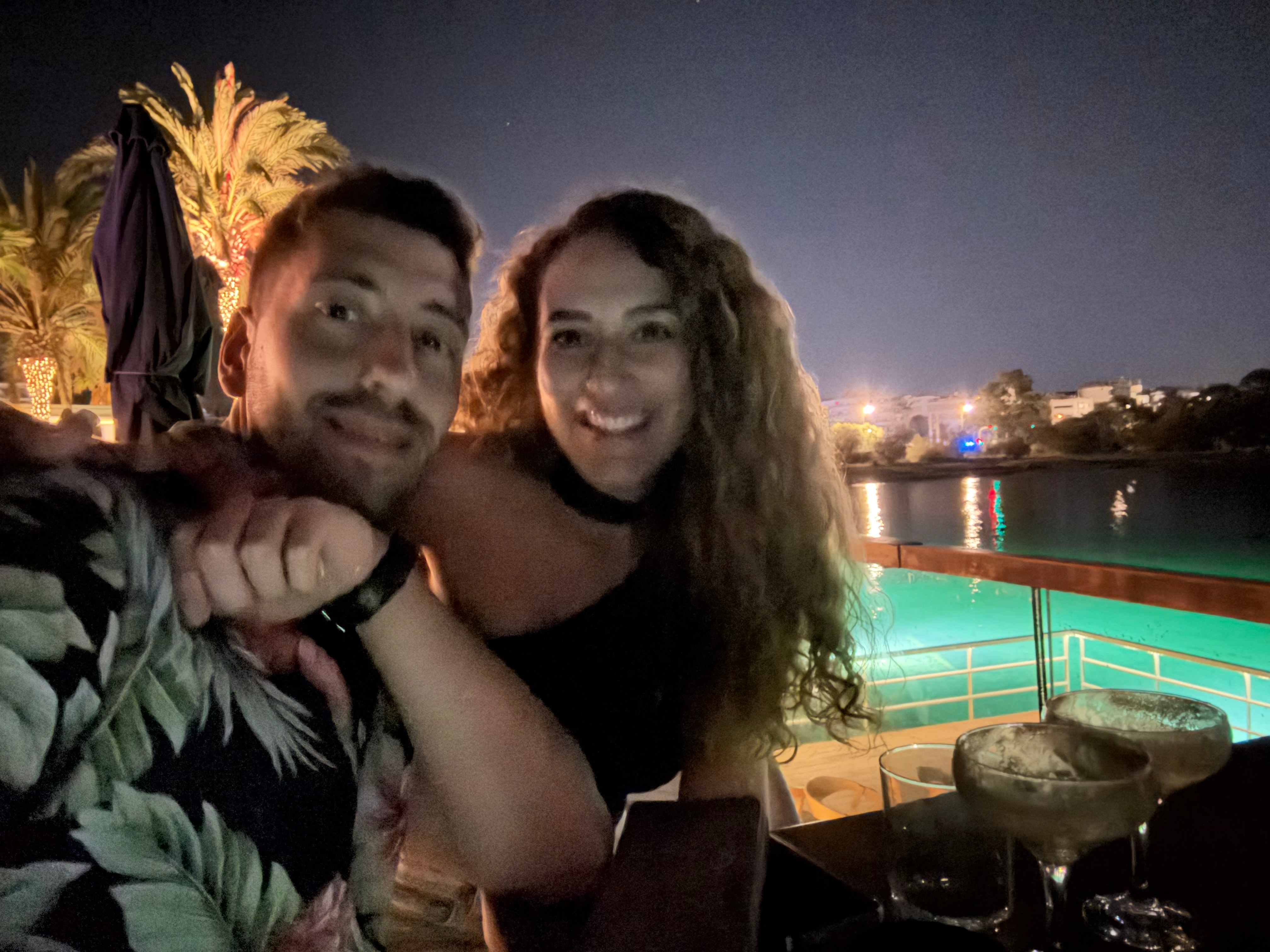 Foivos and Alexandra together by the water at night