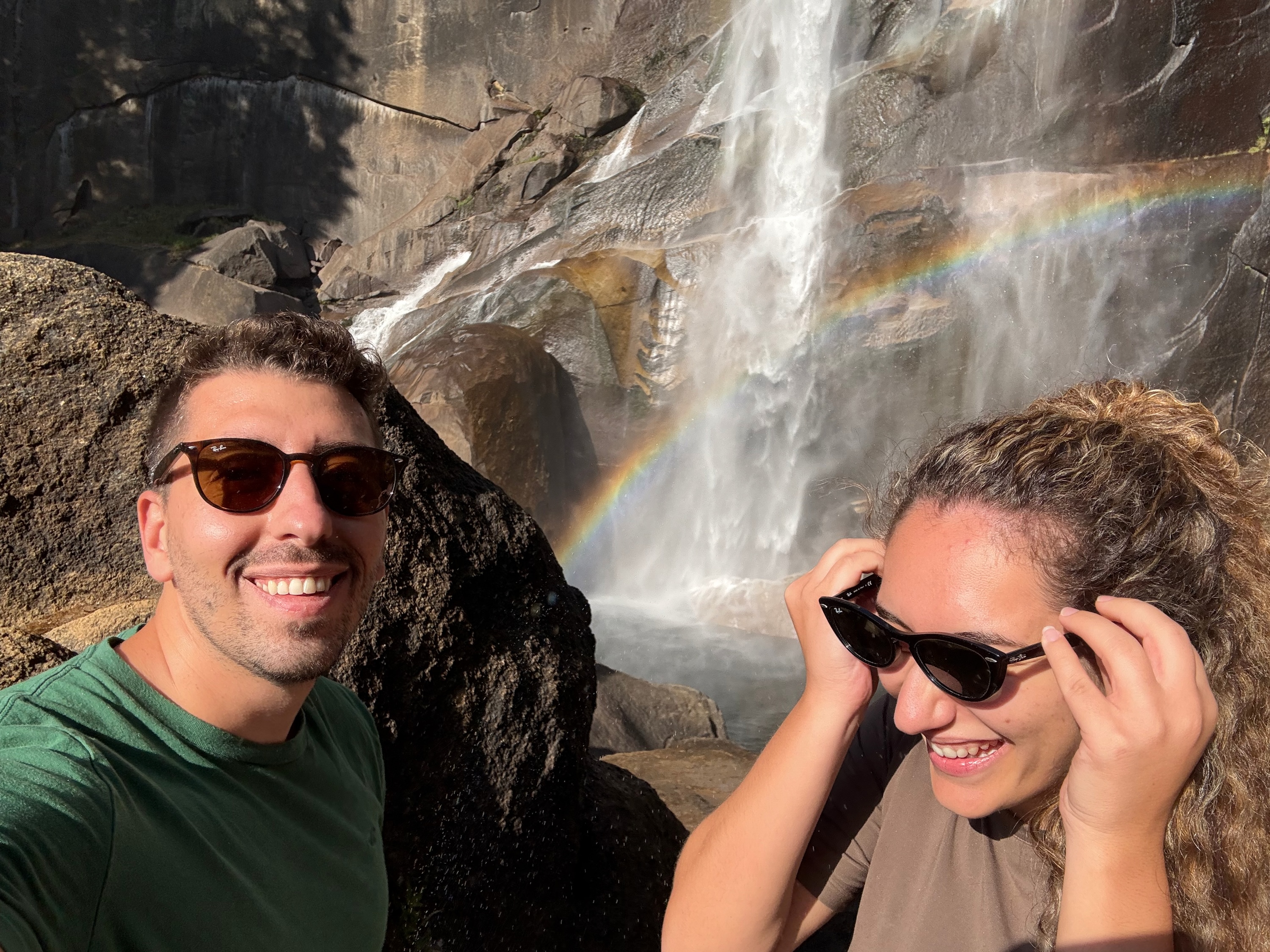 Foivos and Alexandra beside a waterfall and rainbow